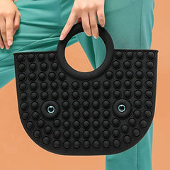 black pop it fidget handbag in hand of a model wearing green pants